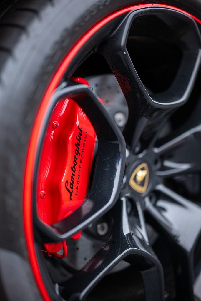 Red performance brake caliper behind an alloy wheel